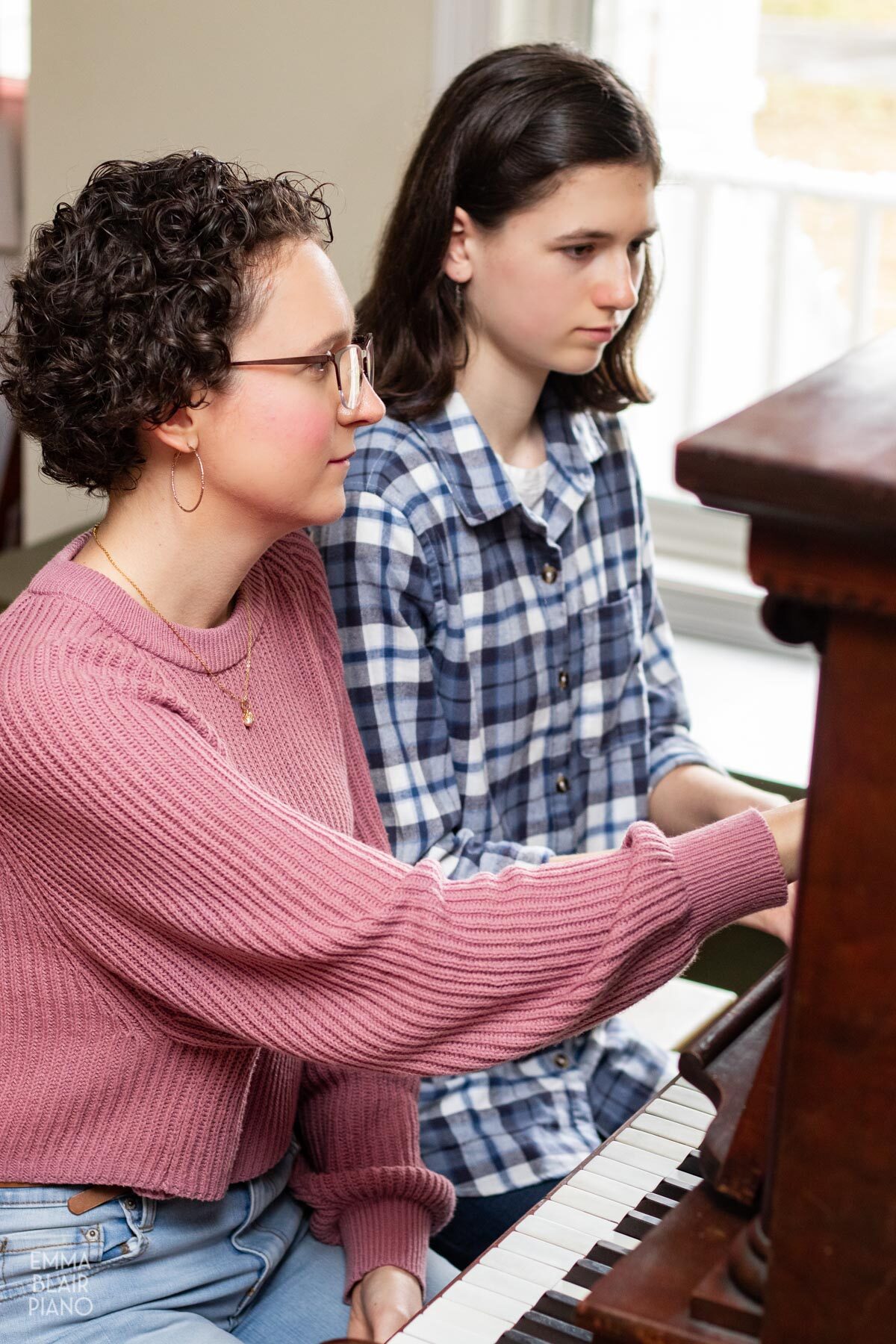 piano teacher pointing out something to her student