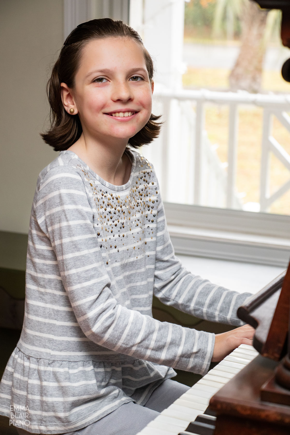 young girl smiling at the piano