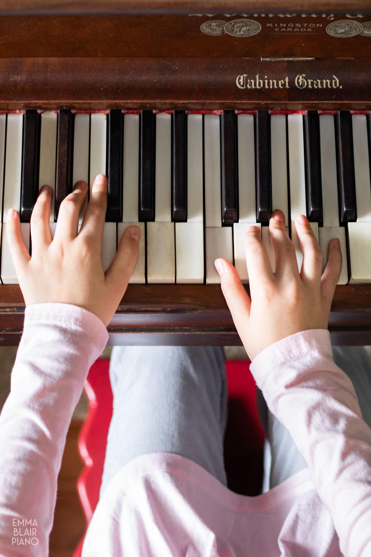 top view of a young girl's hands playing the piano