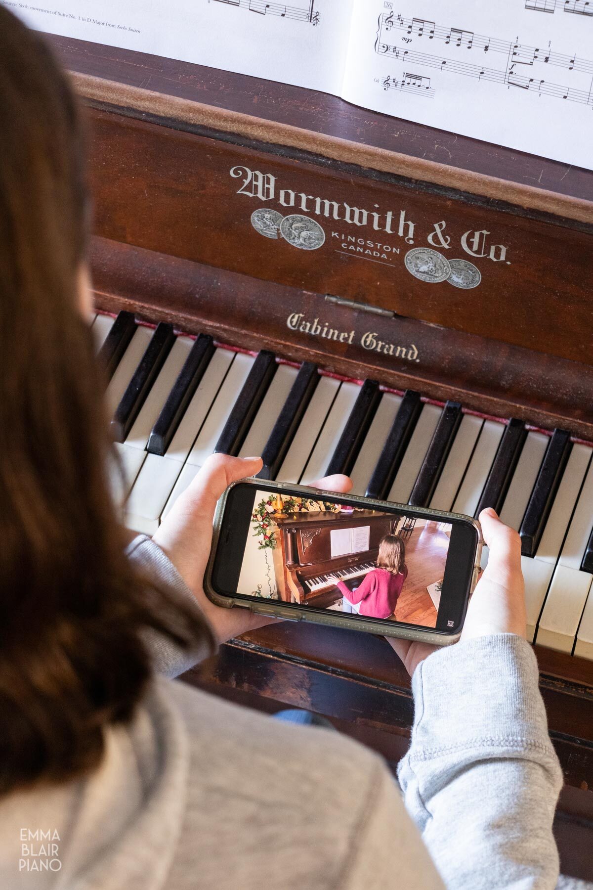 teenage girl watching a piano video on a cell phone