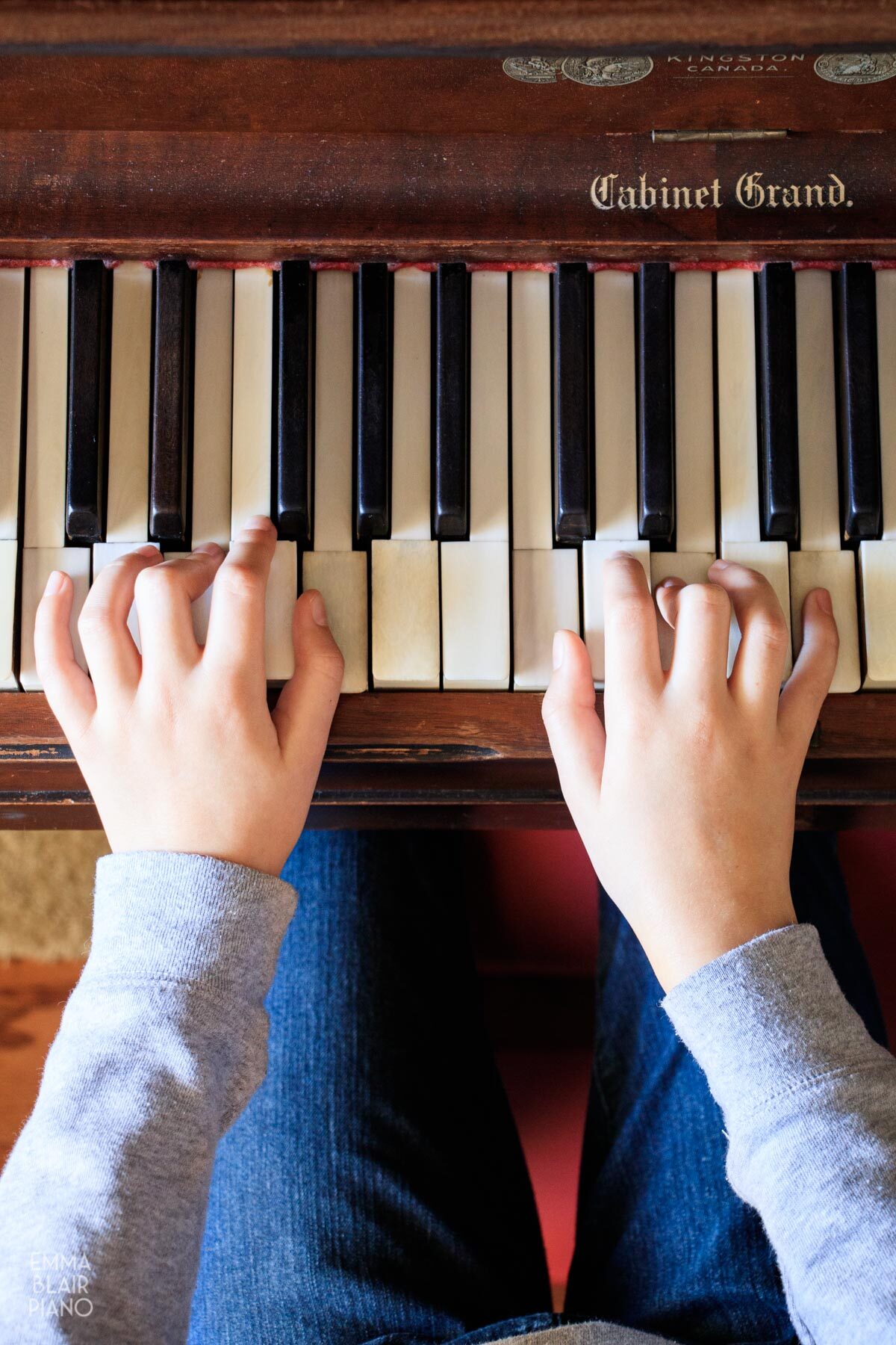 girl playing C major chords on a piano