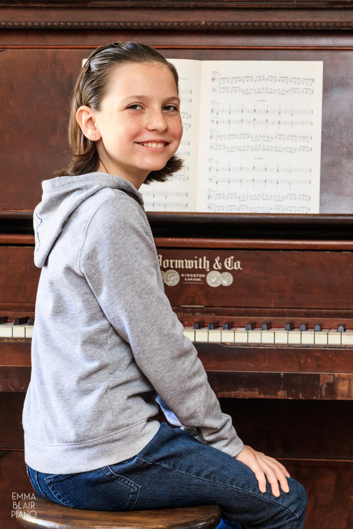 girl sitting at the piano with a book of triads on the music stand