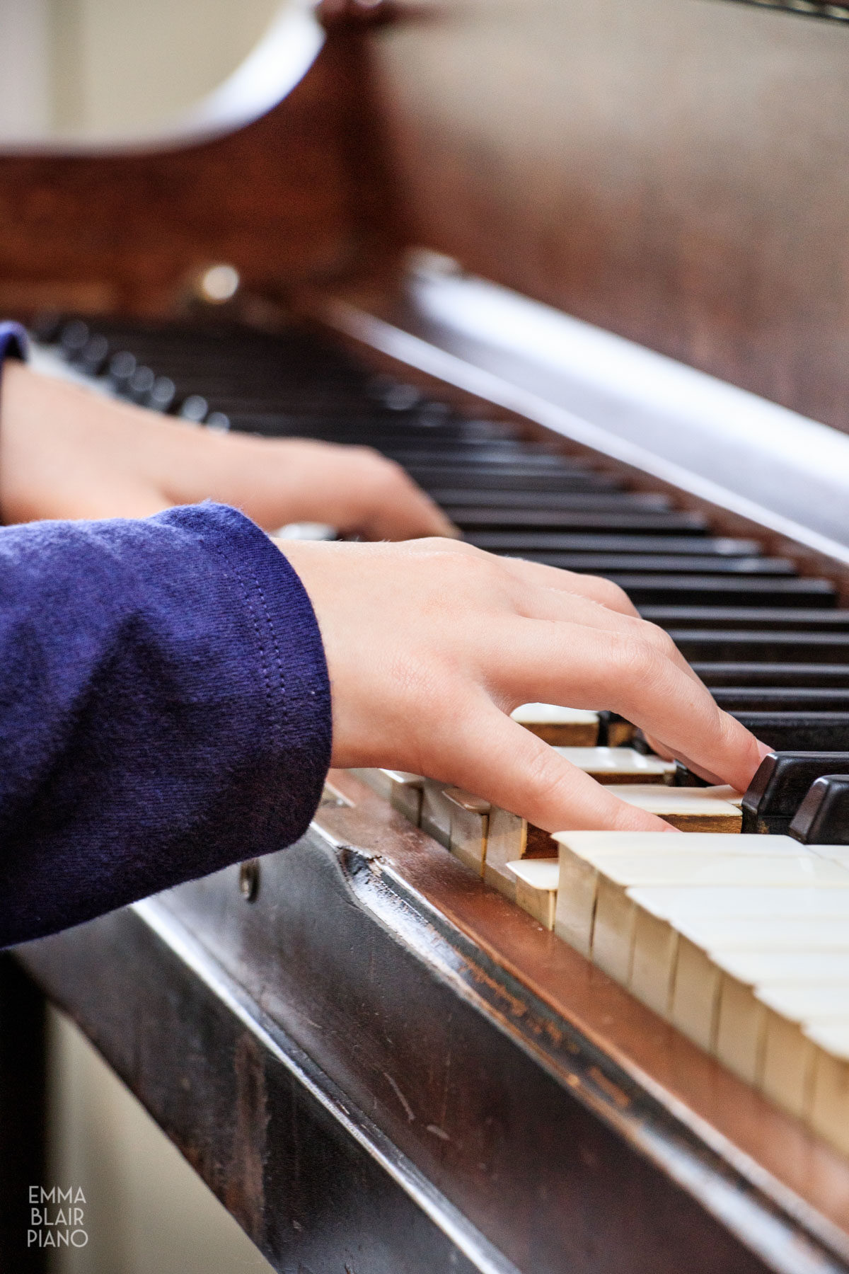 closeup of a young girl's hands playing the piano