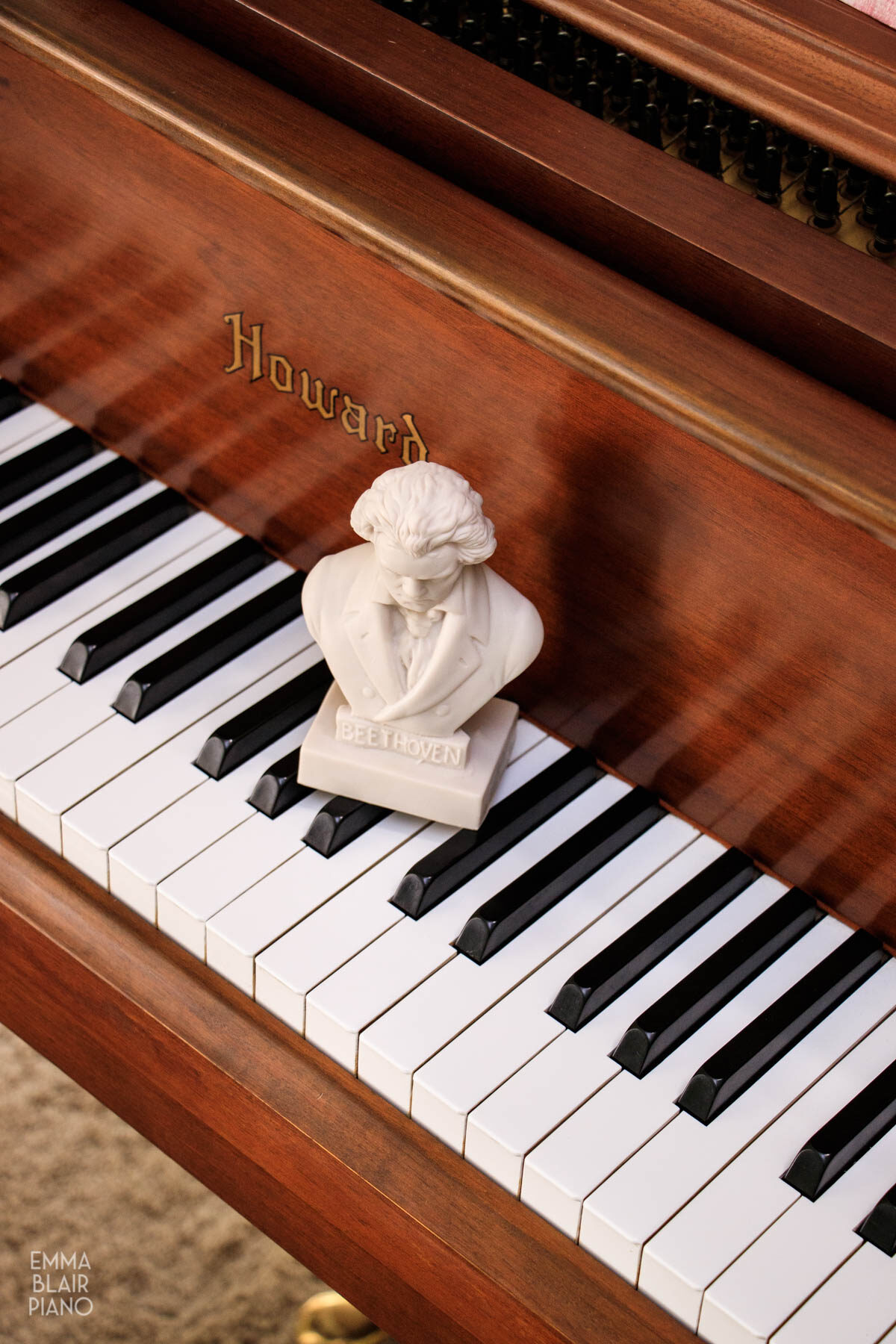 small bust of Beethoven sitting on a piano keyboard