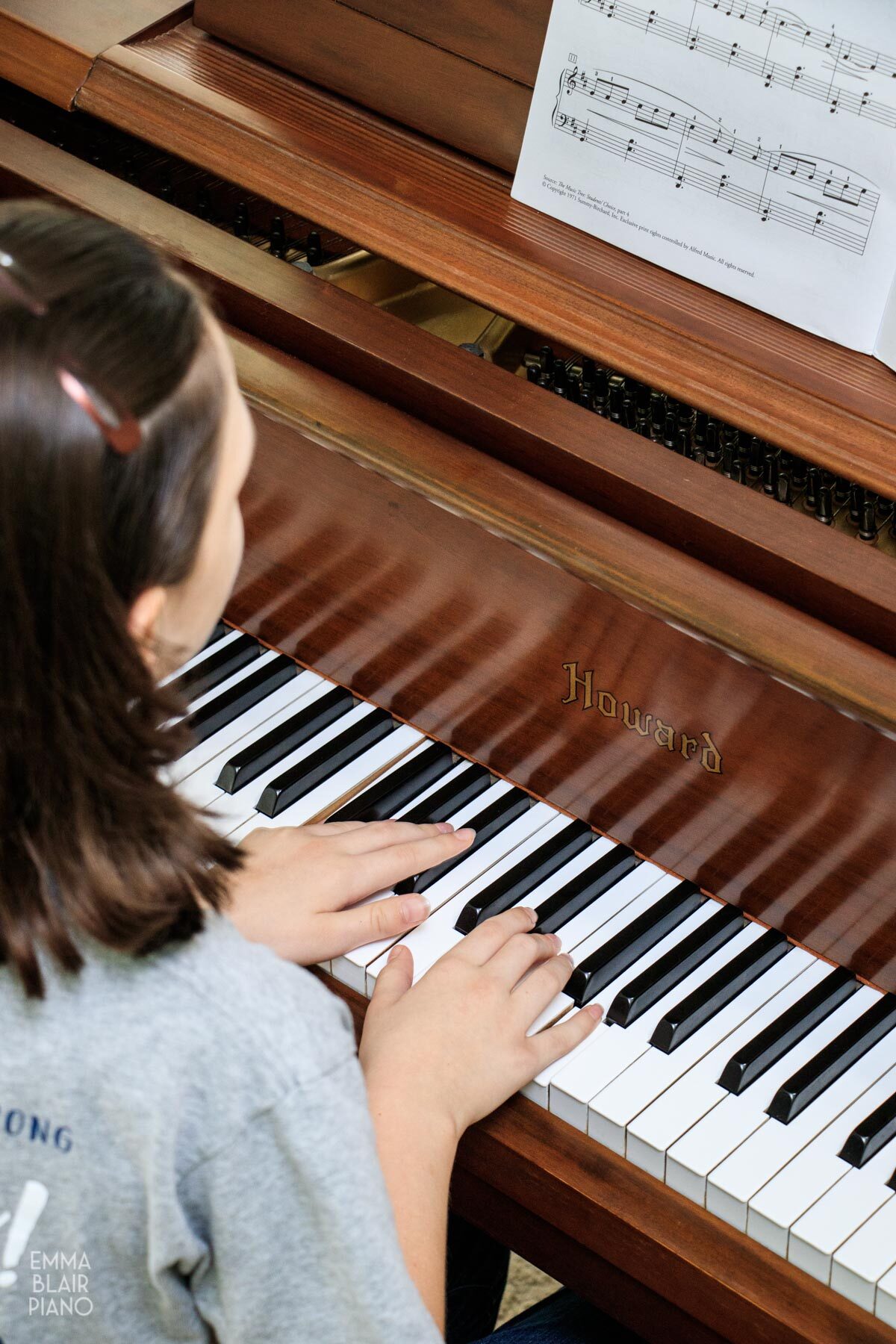young girl playing a classical piece on the piano