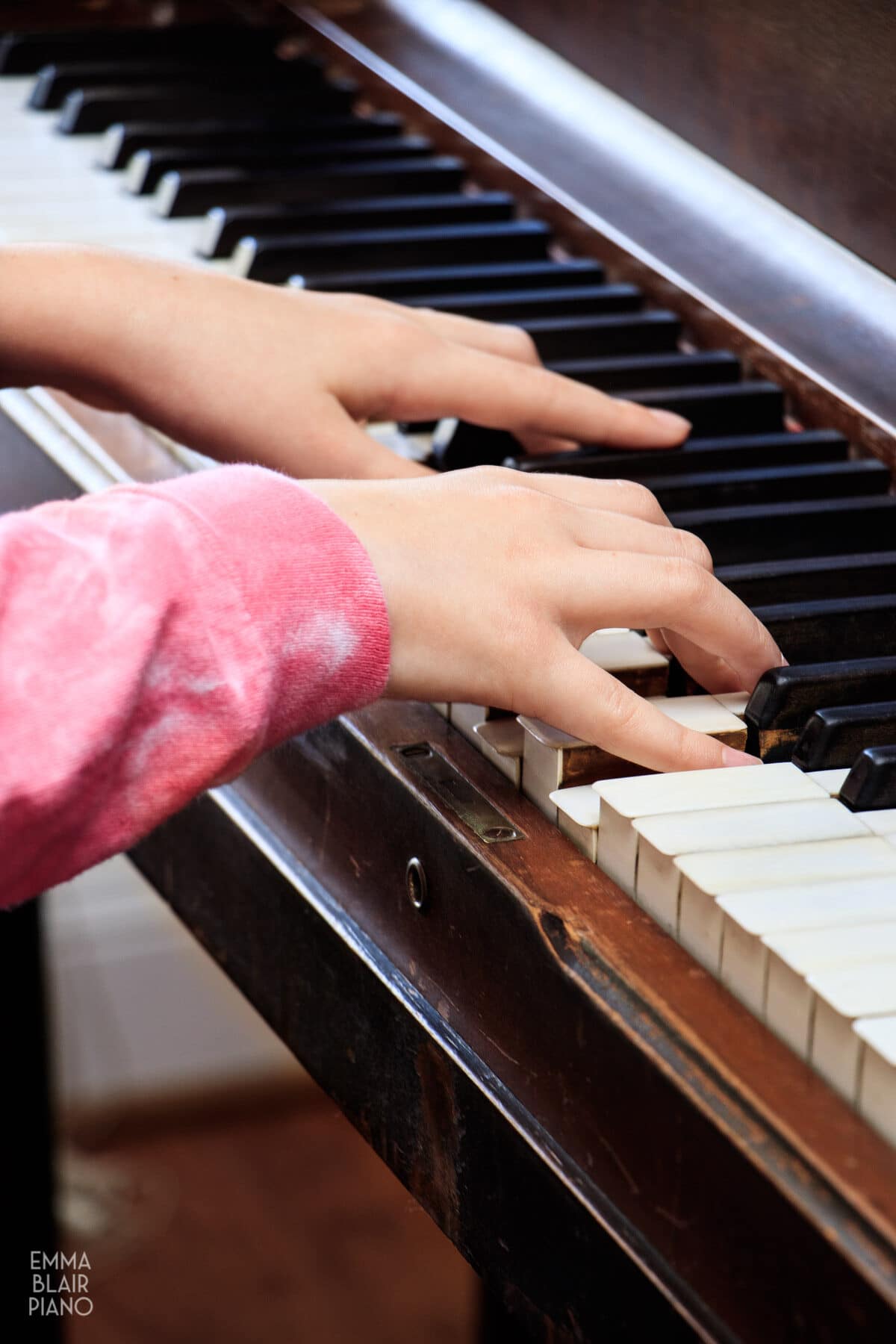 closeup of a young girl's hands playing the piano