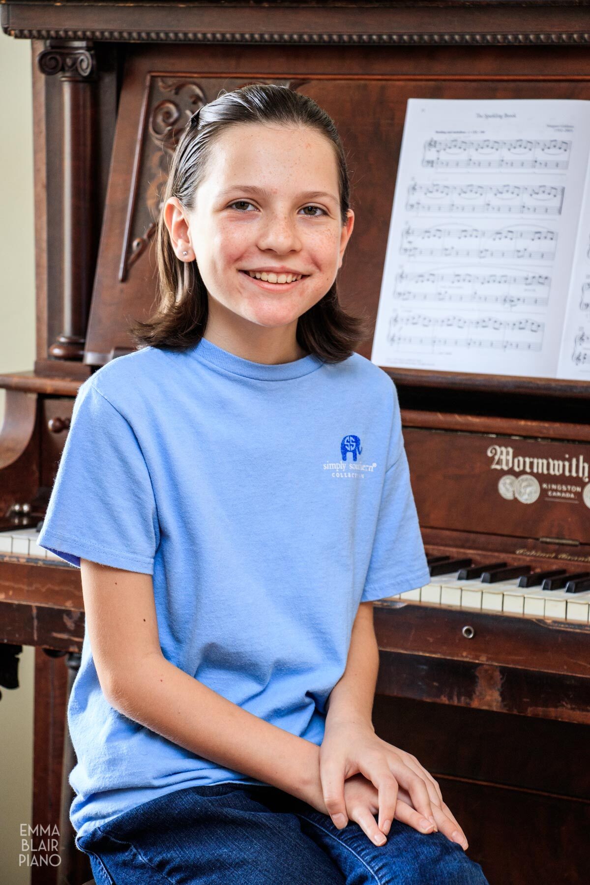 young girl sitting at the piano and smiling