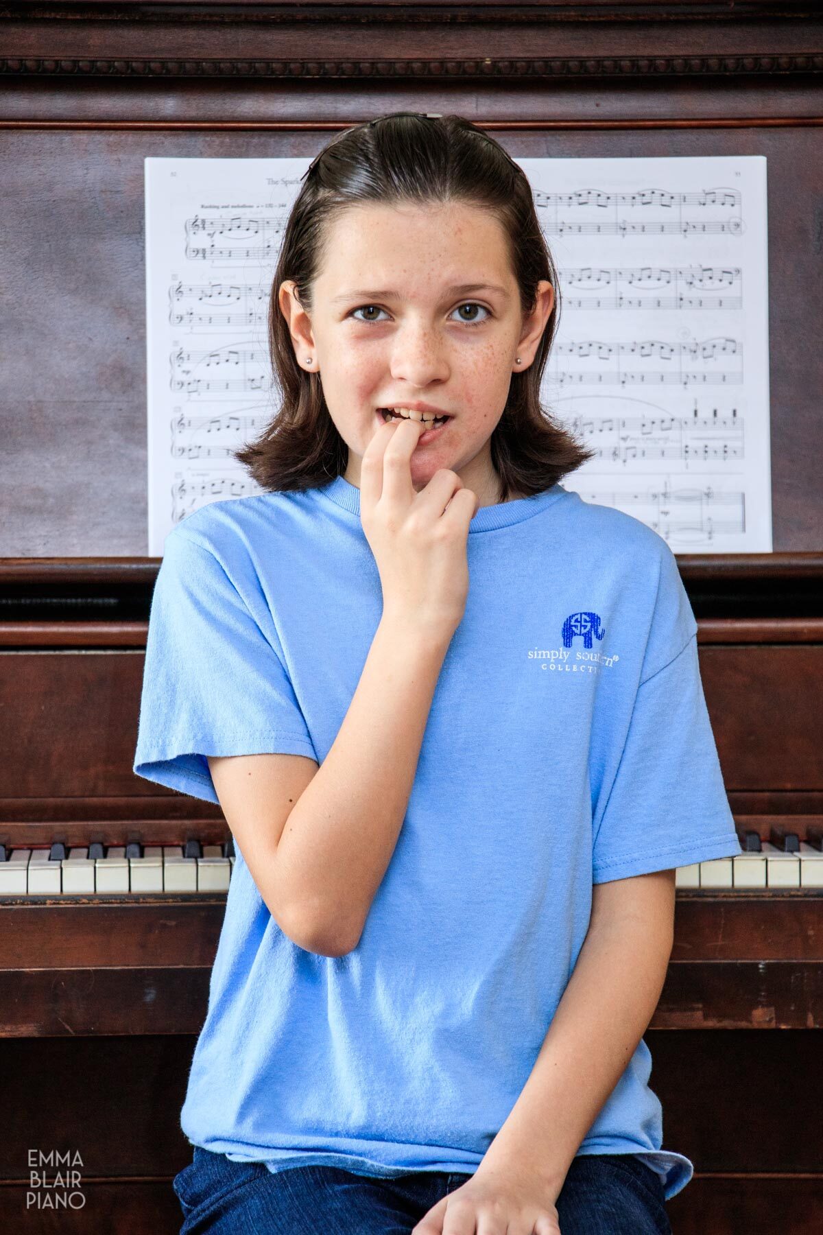 young girl sitting at the piano looking nervous