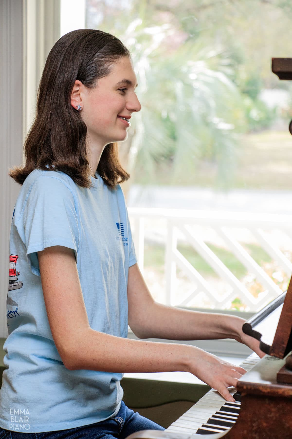 teenage girl playing the piano with a smile and confidence