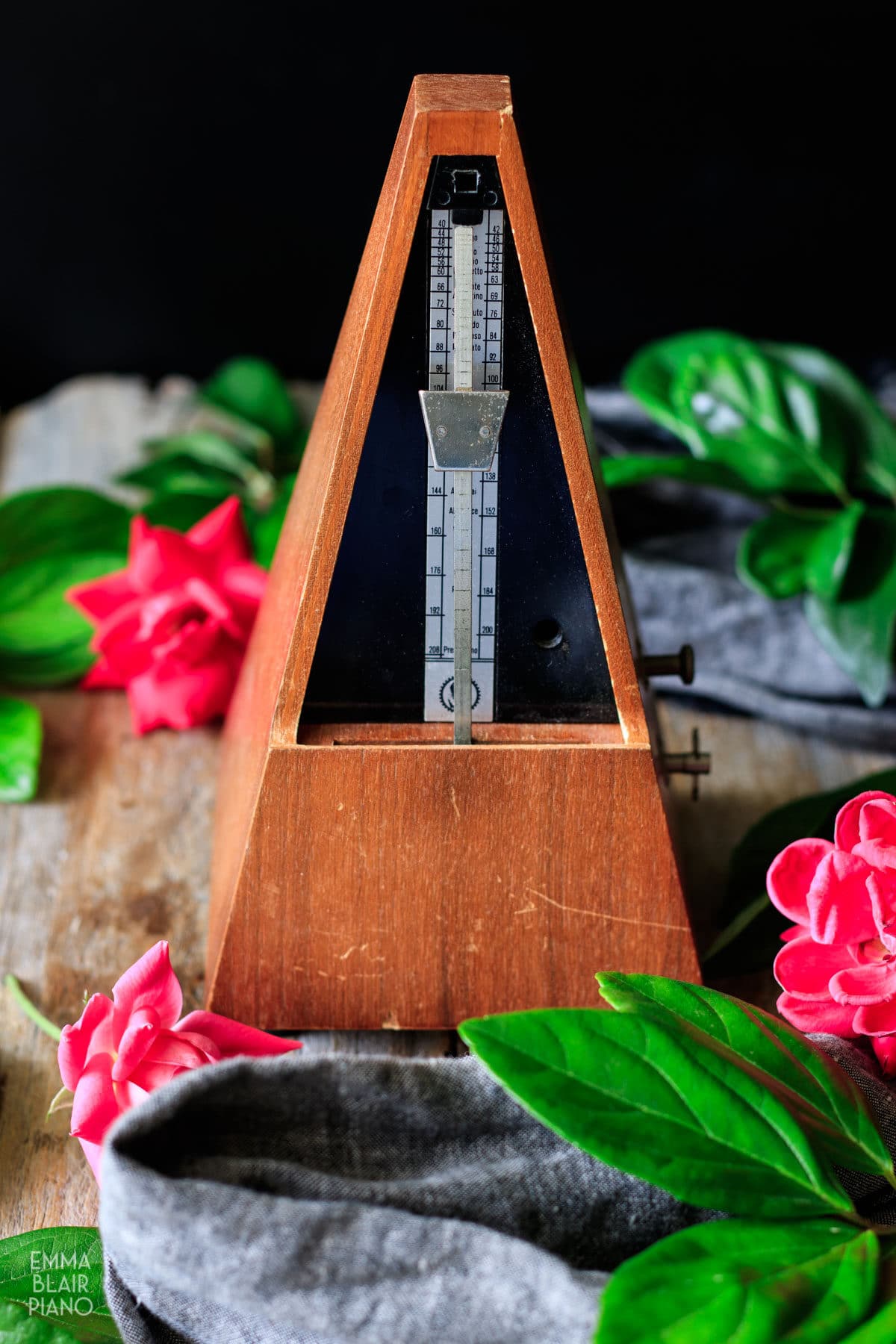 wooden metronome with pink roses and gray linen