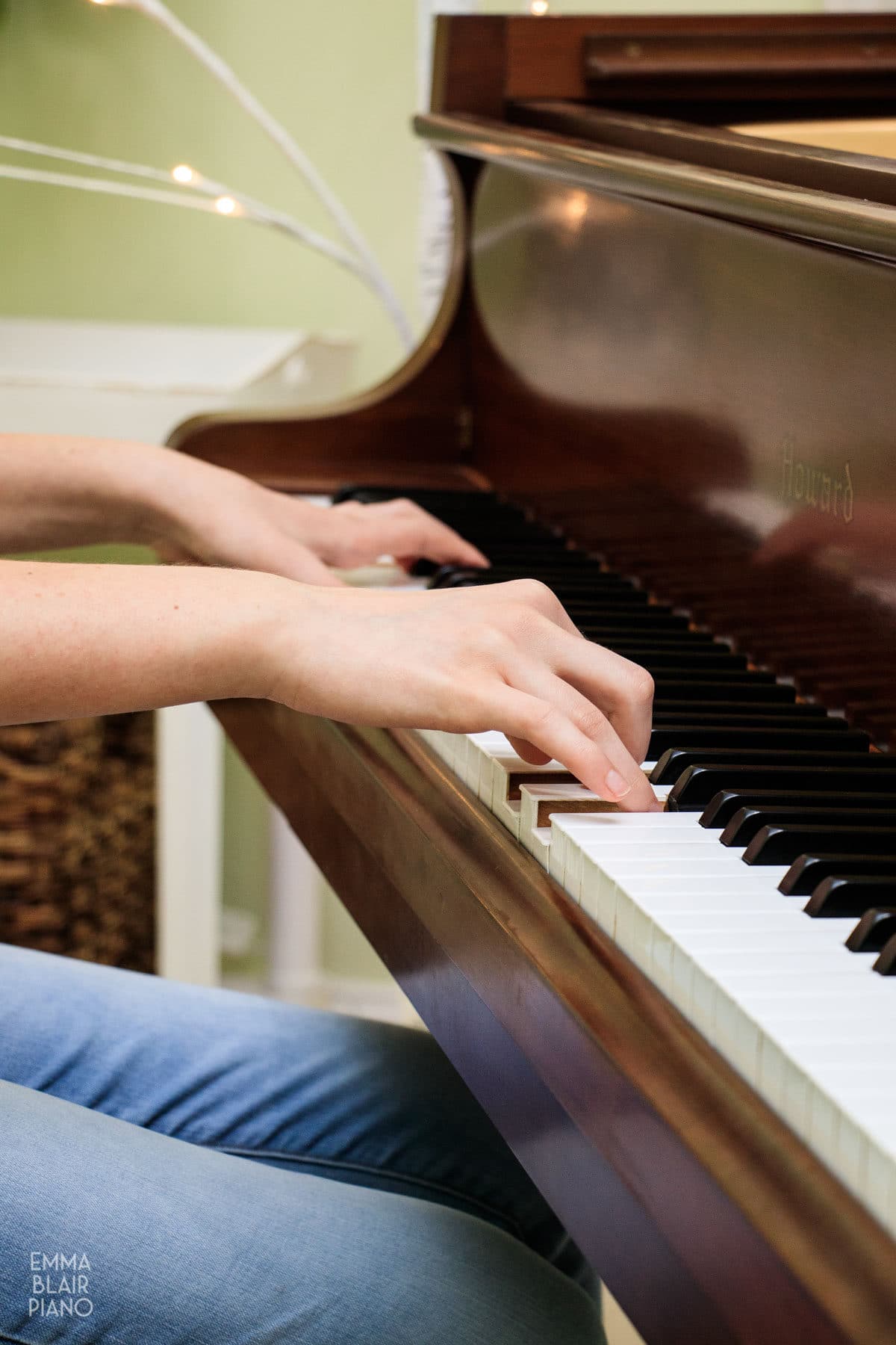 teenage girl playing a brown grand piano