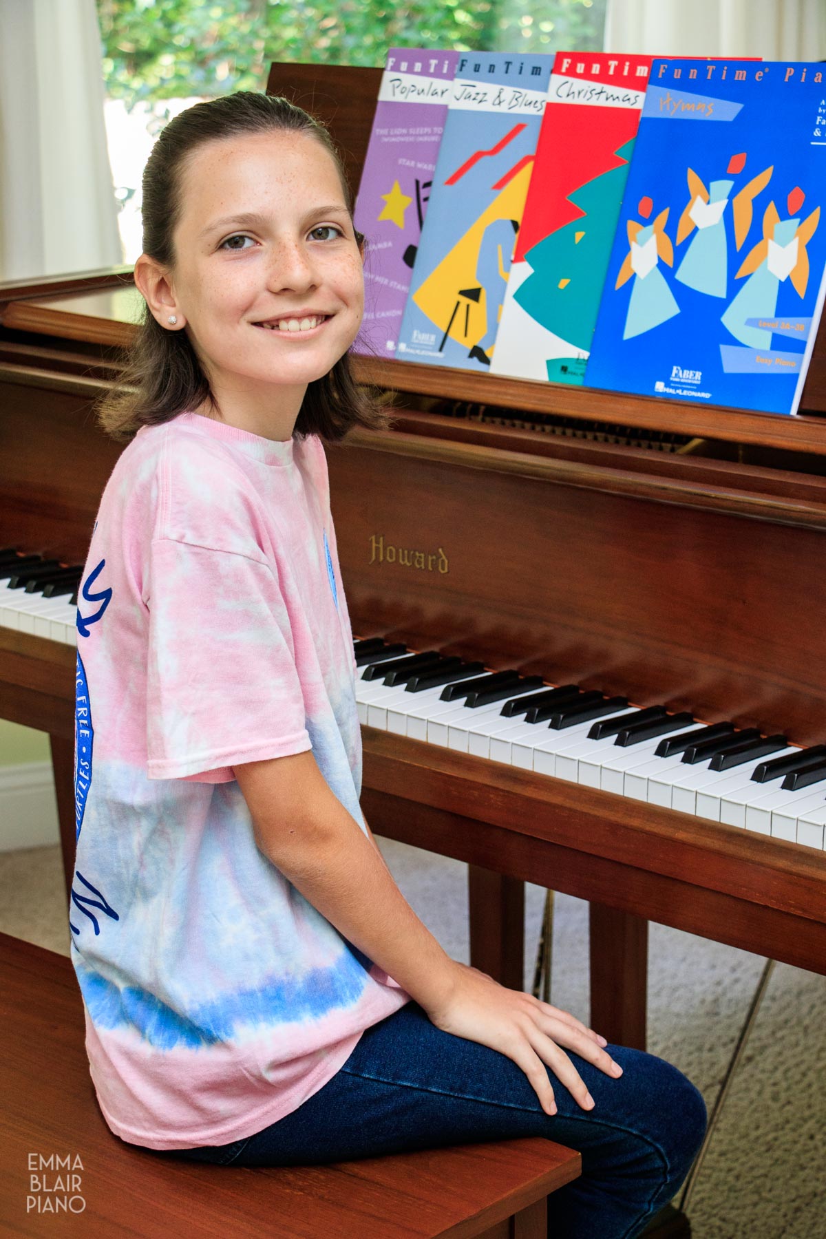 young girl sitting at the piano and smiling