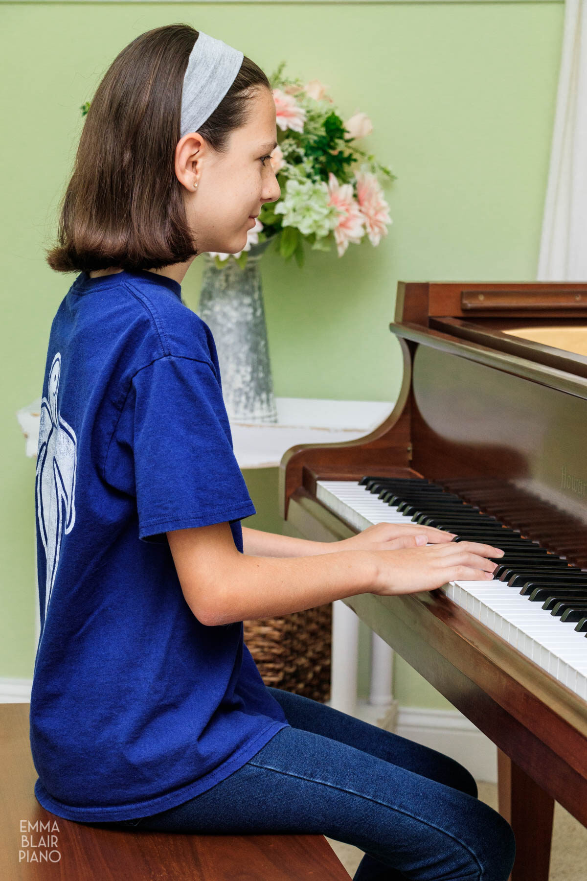 young girl playing a grand piano