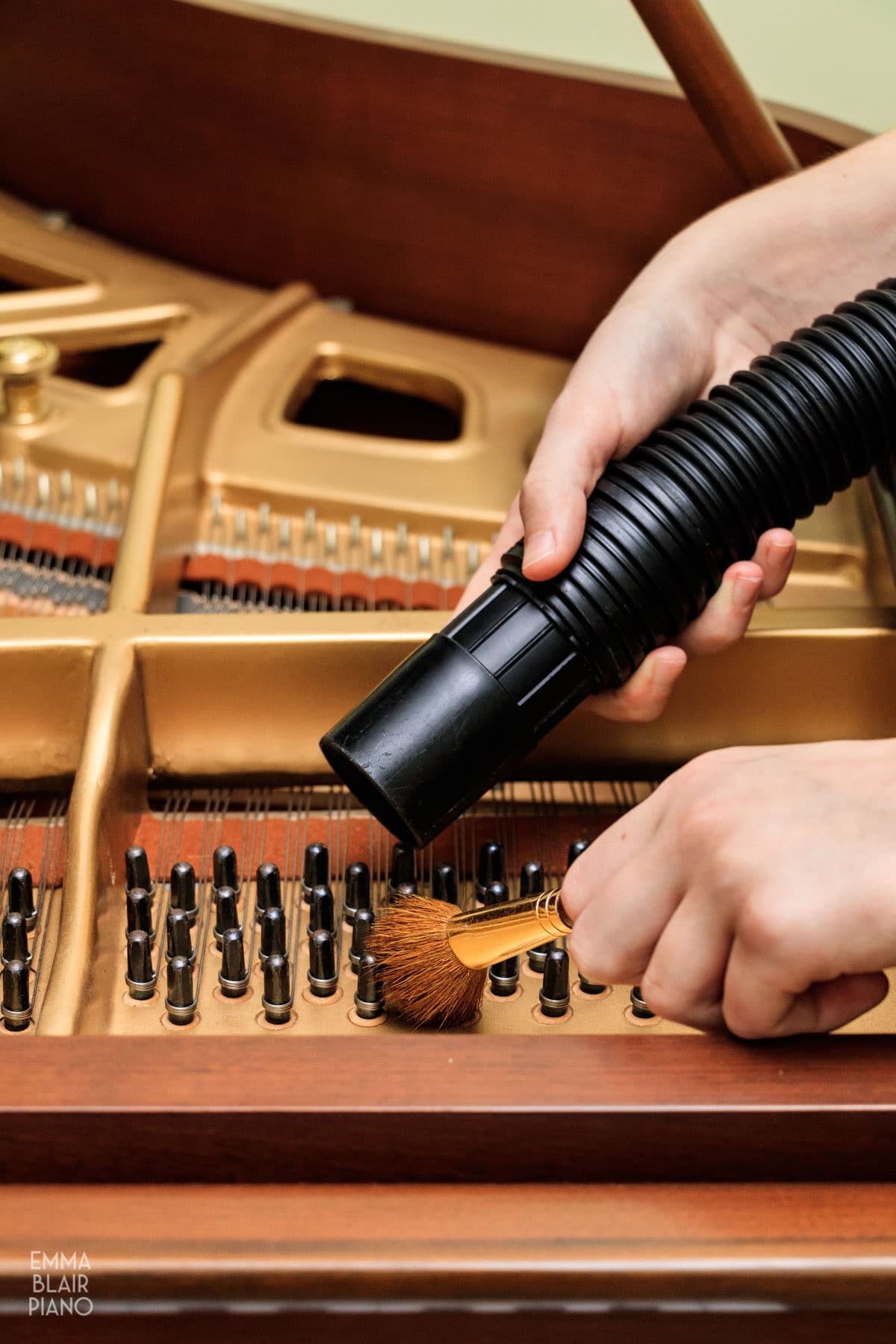 girl brushing and vacuuming dust off of piano tuning pegs