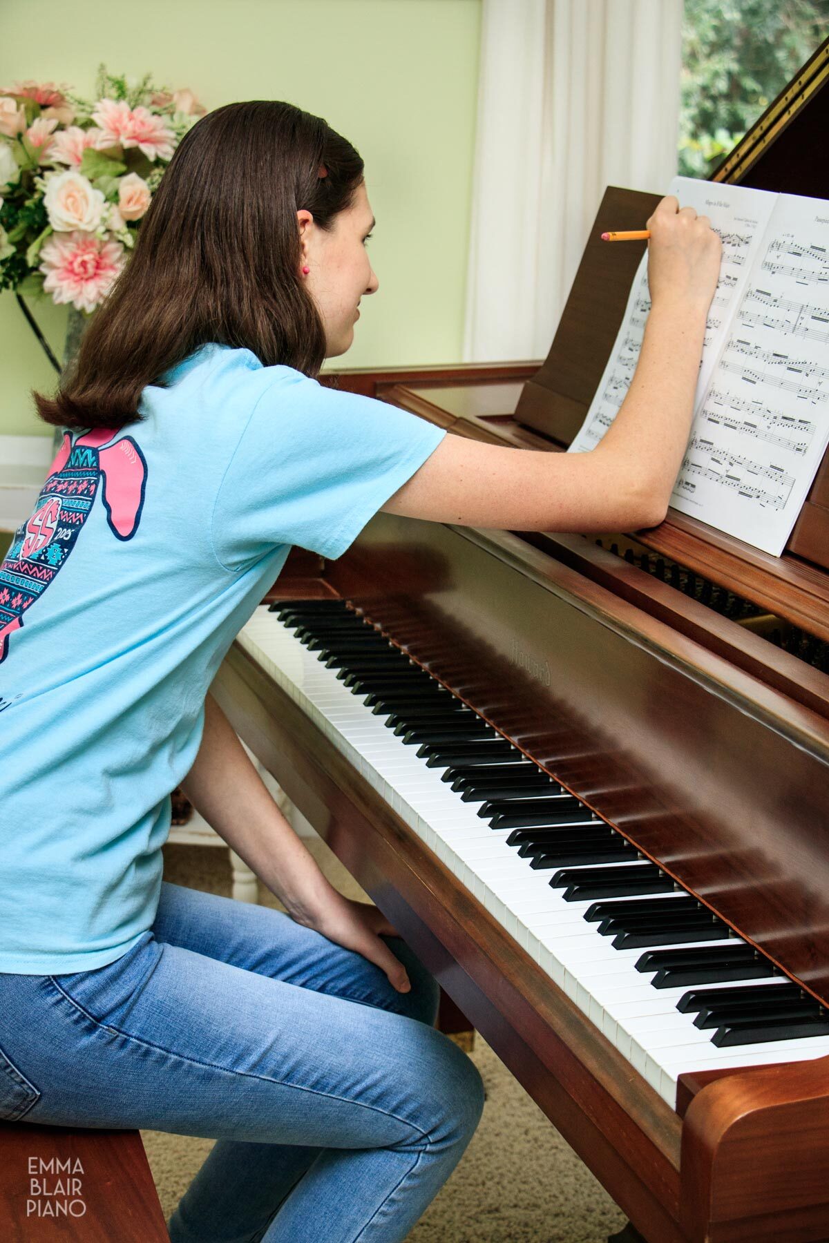 girl making notes on sheet music for a classical piece