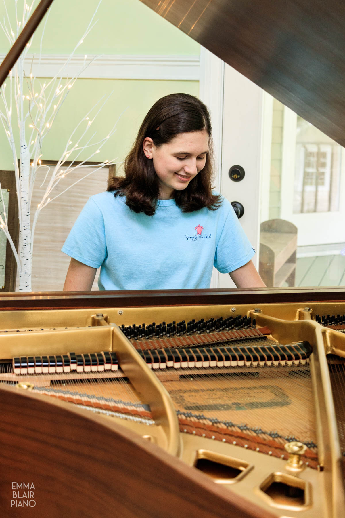 teenage girl smiling as she plays a piano song from memory