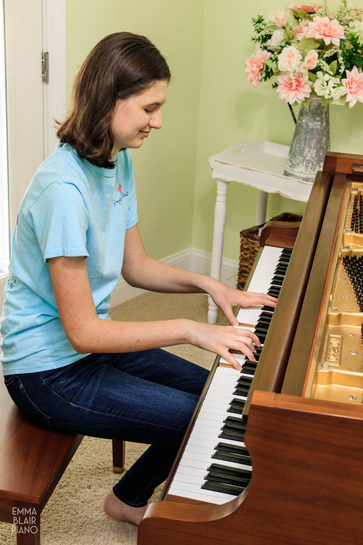 teenage girl smiling and playing a newly tuned grand piano