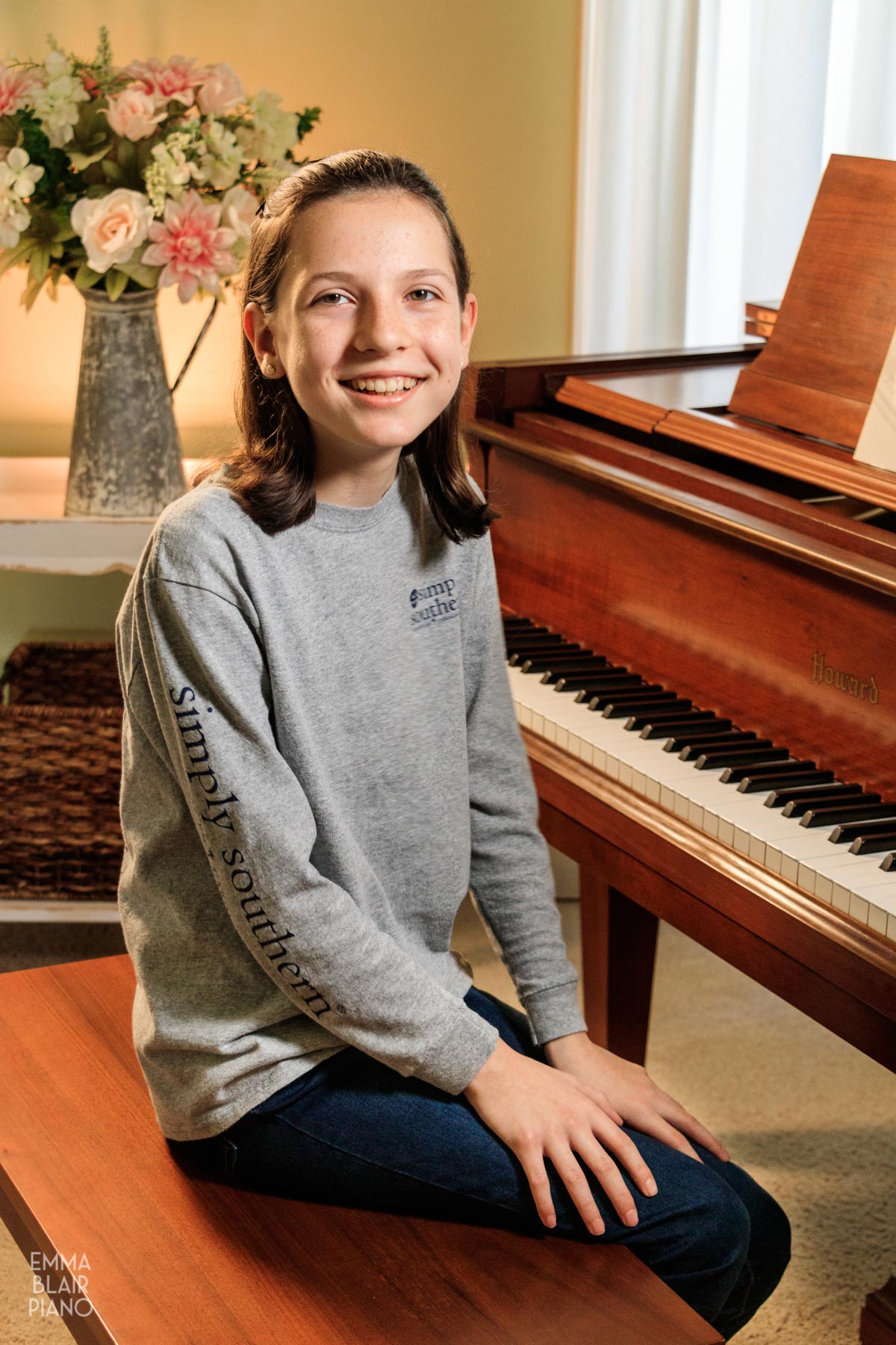 girl smiling with a brown grand piano