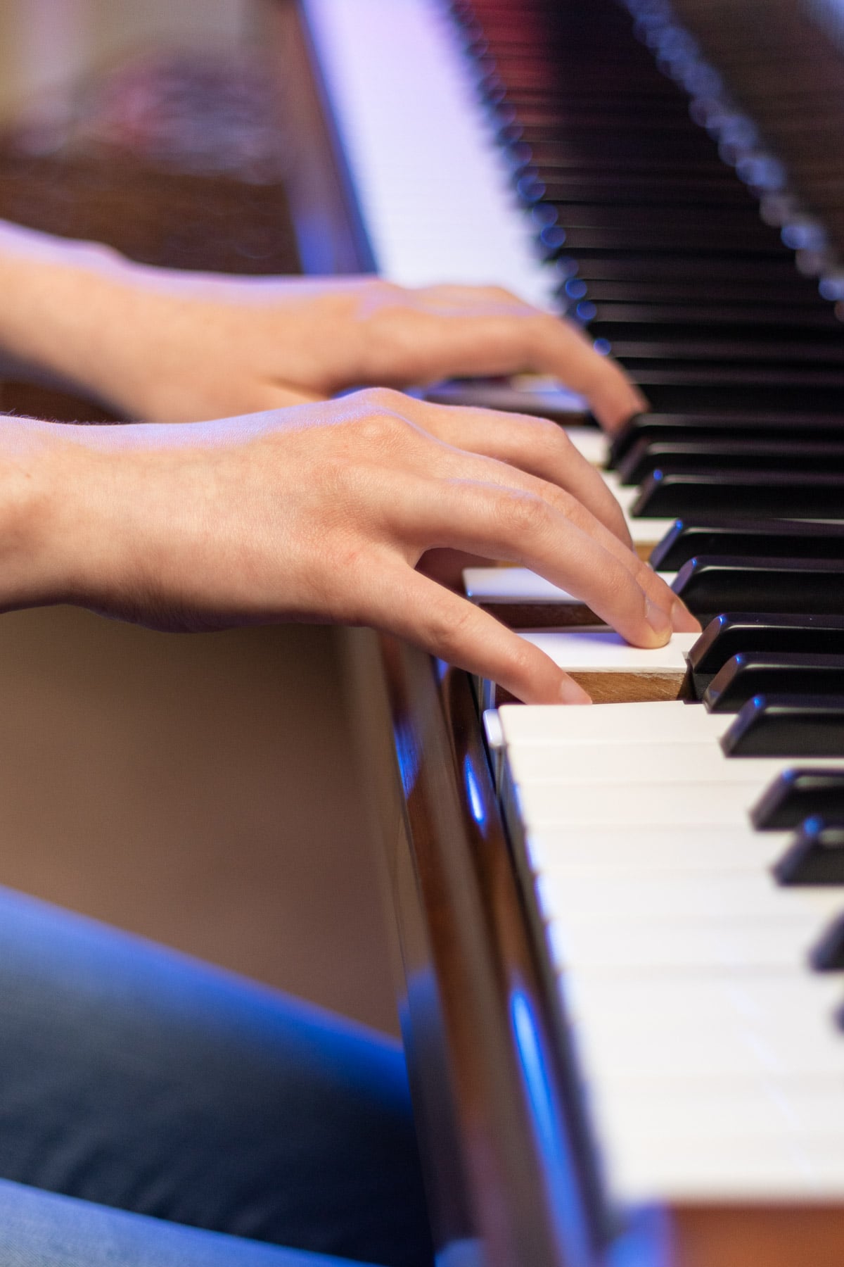 side view of a girl's hands on the piano