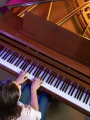 girl playing scales at the piano