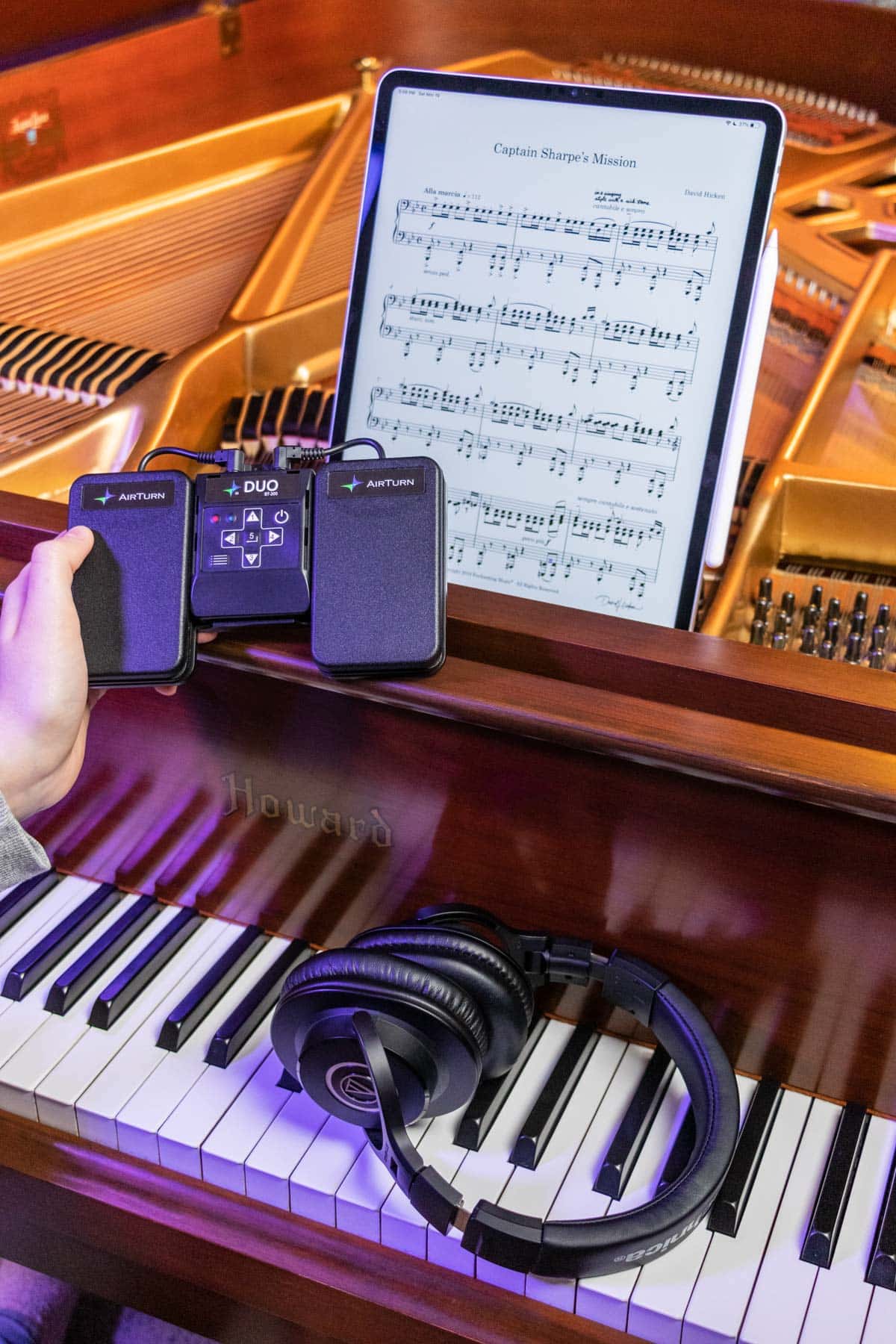 AirTurn Duo pedal, headphones, iPad, and Apple pencil with a piano