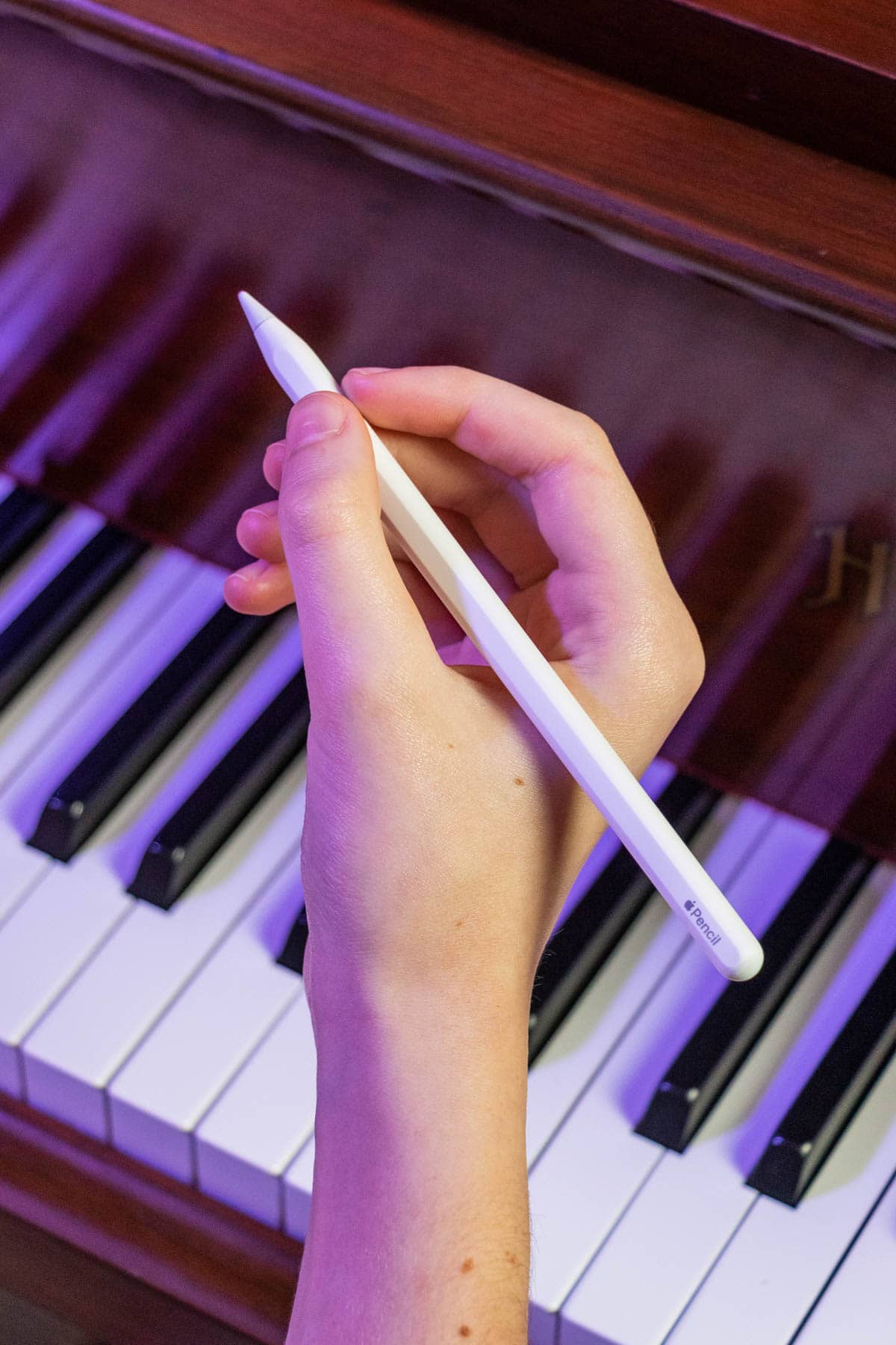 person holding a white Apple Pencil